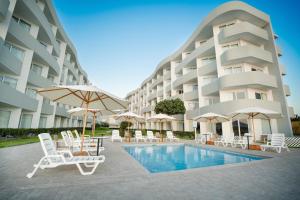 帕拉卡斯的住宿－Casa Andina Select Paracas，游泳池旁的酒店拥有椅子和遮阳伞