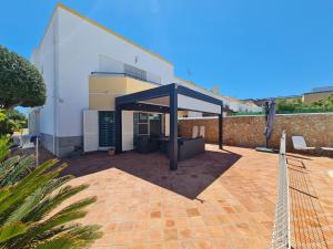 a patio with a black canopy in front of a building at VILLA DO LIMAO in Tavira