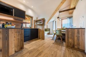 a kitchen with wooden cabinets and a dining room at Forchnerhof Apt 4 in Terento
