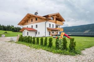a house with a wooden roof and a playground at Forchnerhof Apt 4 in Terento