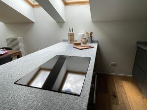 a kitchen with a granite counter top and a kitchen island at Mansarda Malenca in Chiesa in Valmalenco