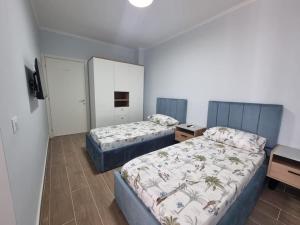 een kamer met 2 bedden en een bureau. bij H&E Sea view 2-Bedroom Apt Qerret in Golem