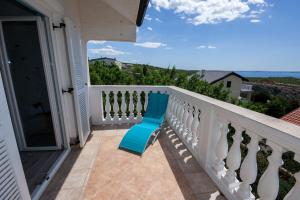 a blue chair sitting on the balcony of a house at Apartment Mikuš in Stinica