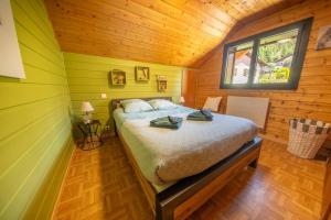 - une chambre avec un lit dans une cabane en bois dans l'établissement Les Marmottes, 10 à 20p avec bb-foot, billard, bar, à Cornimont