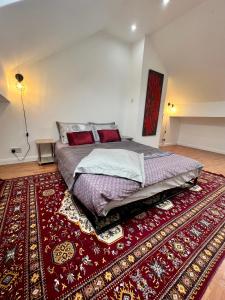 ein Schlafzimmer mit einem großen Bett auf einem roten Teppich in der Unterkunft House in the Heart of Manchester in Manchester