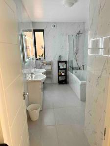 ein Badezimmer mit zwei Waschbecken, einer Badewanne und einem WC in der Unterkunft Luxurious, spacious, sunny & modern apartment in London