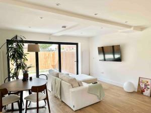 ein Wohnzimmer mit einem Sofa und einem Tisch in der Unterkunft Luxurious, spacious, sunny & modern apartment in London