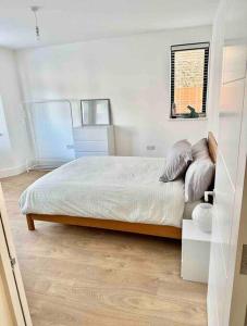 Schlafzimmer mit einem Bett und einem Fenster in der Unterkunft Luxurious, spacious, sunny & modern apartment in London