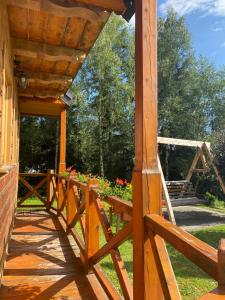 a wooden porch with a wooden fence and flowers at Domek w górach in Nowy Targ +9 photos