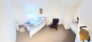 a white bedroom with a bed and a chair at Keeles. in Birr