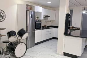 a kitchen with a stainless steel refrigerator and drums at Belle maison avec jardin privatif in Casablanca