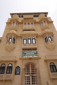 un edificio alto con ventanas y un cartel en él en Jaisalmer Tofu safari en Jaisalmer