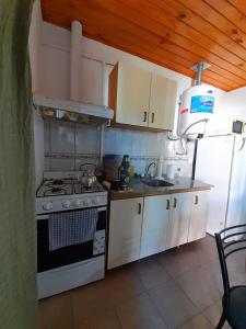 Casitas del Sol في Caseros: مطبخ مع موقد ومغسلة وثلاجة