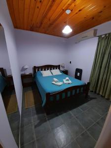 Casitas del Sol في Caseros: غرفة نوم بسرير ازرق وسقف خشبي