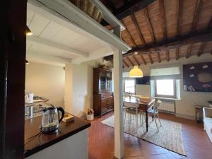 a kitchen and living room with a table and chairs at Appartamento centro storico La Pulcianella con vista in Montepulciano