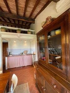 a kitchen with a large wooden cabinet and a table at Appartamento centro storico La Pulcianella in Montepulciano