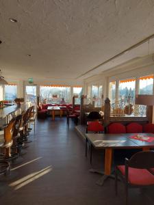 a dining room with tables and chairs and windows at Kuschelig im Allgäu in Scheidegg