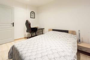 1 dormitorio con 1 cama y 1 silla negra en Saint Antoine en montagne, en Saint-Jean-de-Maurienne