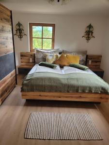 Un dormitorio con una gran cama de madera con almohadas en Anne's Wohlfühlplatzl, en Steinberg am Rofan