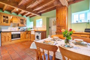 a kitchen with a table with flowers on it at Finest Retreats - Marmaduke Cottage in Sancton