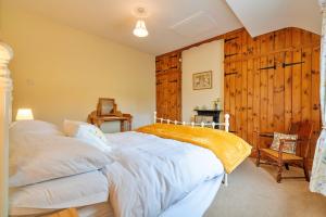 a bedroom with a bed and a wooden wall at Finest Retreats - Marmaduke Cottage in Sancton