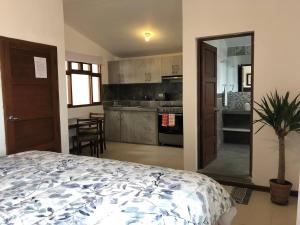 a bedroom with a bed and a kitchen with at Charming 1-Bed Studio in Huanchaco with balcony in Huanchaco