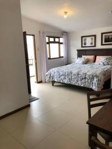 a bedroom with a bed and a table in it at Charming 1-Bed Studio in Huanchaco with balcony in Huanchaco
