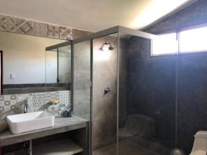 萬查科的住宿－Charming 1-Bed Studio in Huanchaco with balcony，一间带水槽和玻璃淋浴的浴室