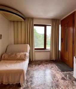 Стаи за гости Алба في كازانلوك: غرفة نوم بسريرين ونافذة كبيرة