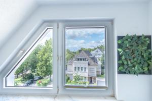 een open raam met uitzicht op een huis bij Essens Grüne Mitte !Zentral, Grün und Heimisch! Free Parking, Free Netflix in Essen