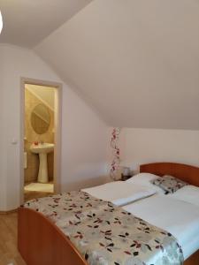 a bedroom with a bed and a bathroom with a sink at CASA HOBAN in Baia Mare