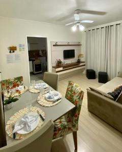 uma sala de estar com uma mesa e um sofá em APTO 14 - ENSEADA, PRÓXIMO REGIÃO DO PÃO DE AÇUCAR no Guarujá