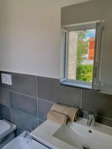 La salle de bains est pourvue d'un lavabo et d'un miroir. dans l'établissement La Casetta, à Carrù