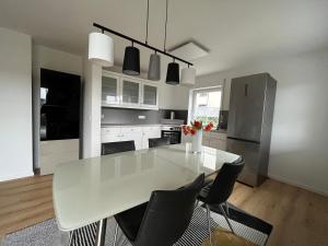 a white kitchen with a white table and chairs at Ferienwohnung mit Garten und Ausblick in Windorf