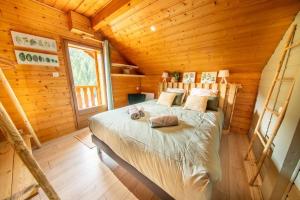 a bedroom with a bed in a wooden cabin at F'amis Lodge, 10 à 20p et sauna in Cornimont