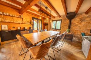 a dining room with a wooden table and chairs at F'amis Lodge, 10 à 20p et sauna in Cornimont
