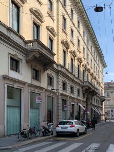 a white car parked in front of a large building at Brera Apartments Alla Scala in Milan