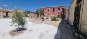 an empty courtyard in an old building with a tree at Il Casale Appartament&Rooms in Burgio