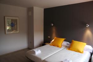 a bedroom with two yellow pillows on a bed at Hostal Totsompops in Colera