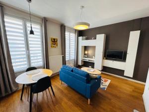 een woonkamer met een blauwe bank en een tafel bij Le Superbe Thillois - Hypercentre - Sensationnel in Reims