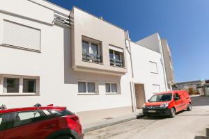 two cars parked in front of a white building at Ferrel Apartment in Ferrel