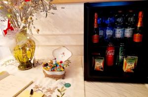 una mesa con una botella de cocacola y un jarrón en Luxury House B&B, en Bassano del Grappa