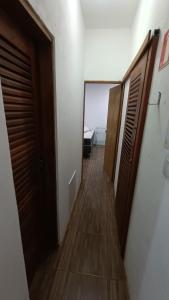 un pasillo que conduce a una habitación con puertas de madera en Albacora Eco Residence, en Imbassai