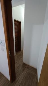 pusty korytarz z drzwiami i drewnianą podłogą w obiekcie Albacora Eco Residence w mieście Imbassai