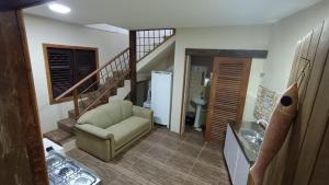 a living room with a chair and a staircase at Albacora Eco Residence in Imbassai