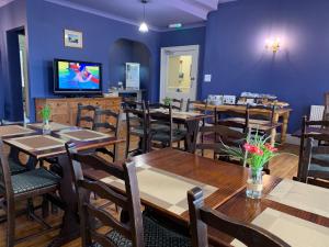 een eetkamer met tafels en stoelen en een tv bij The Kelvin Hotel in Oban