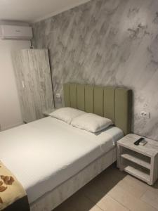 1 dormitorio con 1 cama con cabecero verde en Villa Raul, en Costinesti