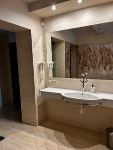 een badkamer met een wastafel en een spiegel bij BeigeRoom in Warschau