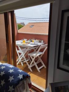 a balcony with a table and chairs on a balcony at MC LAGOS, Bueu in Pontevedra