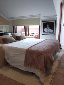 a bedroom with a large white bed with brown pillows at MC LAGOS, Bueu in Pontevedra